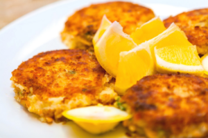 crab cakes on a white plate with lemon wedges on top in marathon florida
