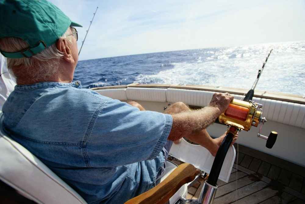 Elderly man sitting in boat facing the ocean deep sea fishing in the Florida Keys
