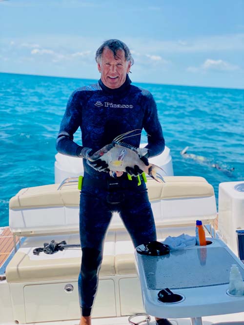 Man wearing scuba suit holding a hogfish caught in the Florida Keys