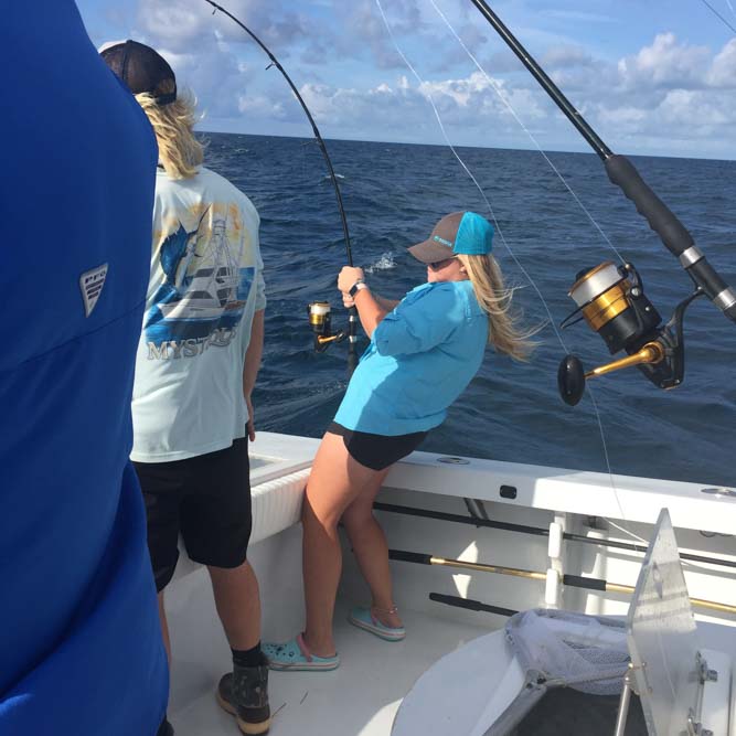 Girl reeling in a fish from a boat in the Florida Keys